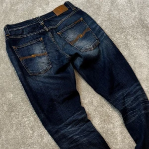 Nudie grim tim jeans - Tja! Säljer dessa schyssta blå Nudie ”Grim Tim” jeansen med fet tvätt! Jeansen är i bra skick, inga defekter. Size 34/32. Skriv vid funderingar!