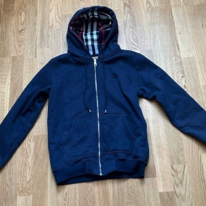 Marinblå zip-hoodie från Burberry - Snygg marinblå hoodie med dragkedja från Burberry. Storleken är M men passar mer till S.
