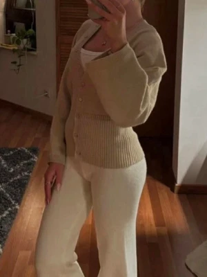 Beige kofta - Helt ny, aldrig använd! Populär beige kofta med knappar framtill och bred ribbad midja. Storlek S.