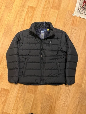 Polo Ralph Lauren Puffer jacket  - Snygg svart pufferjacka från Polo Ralph Lauren med hög krage och dragkedja framtill.  Helt ny med tags kvar 🤩 Fin kvalitet ‼️Fraktas inom 24h, Snabb leverans ‼️ Priset går att pruttas vid snabb affär 👍