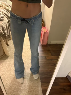 Ljusblå bootcut jeans från Bershka - Säljer ett par ljusblå bootcut jeans från Bershka i storlek 32. Jeansen har låg midja, klassisk femficksmodell och är tillverkade i denim. Perfekta för dig som gillar retrovibbar och en avslappnad look.endast använda 1 gång