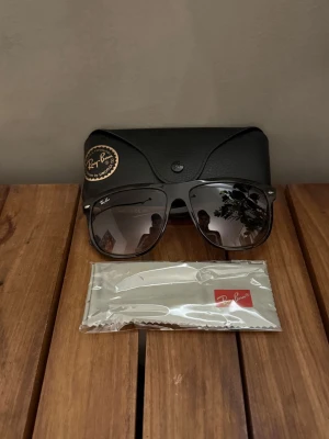 Svarta Ray-Ban solglasögon RB4147 - Snygga svarta Ray-Ban solglasögon modell RB4147 med klassisk rektangulär form. Kommer med originalfodral och putsduk. Perfekta för dig som vill ha en tidlös och cool look i sommar.