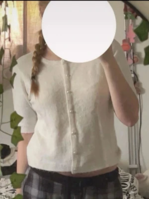 Vit kortärmad kofta med pärlknappar - Söt vit kofta med korta ärmar och pärlknappar framtill. Materialet ser mjukt och skönt, inte stickig💕