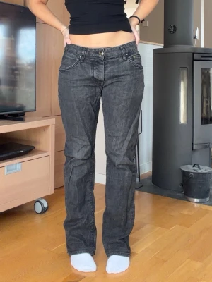 Svarta bootcut jeans med låg midja - Säljer ett par svarta bootcut jeans med låg midja och klassiska fem fickor. Jeansen har en snygg tvättad look och stängs med knapp och dragkedja. Perfekta för dig som gillar en avslappnad men ändå trendig stil. Har två hål inuti byxorna men inget som syns utpå. Syns på de sista bilder. Jag är 163 för referens 
