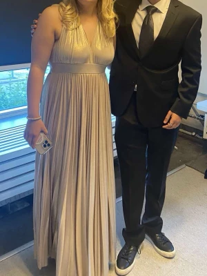 Balklänning öppen rygg  - Säljer nu min balklänning i champange färg som jag använde 2023. Storlek M. Jag är 170 och är perfekt i längden. Ryggen är även helt öppen med knuten runt halsen. Endast använd en gång! Köpt för ca 5000kr