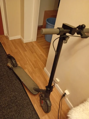 NAVEE elscooter, bra skick.  - Säljer en navee elscooter med tydlig digital display på styret som visar hastighet och batterinivå. Scootern har grå handtag, stora hjul och laddas via kabel. Modern design och robust ram i metall och plast. Perfekt för att ta sig runt i stan på ett smidigt sätt. 20 kmh är max hastigheten. Laddare medföljer. 