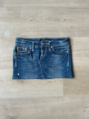 Blå Y2K Mini Skirt Jeanskjol ZCO Jeans Embroidery  - Mycket fin kjol i blå färg. Kjolen är i mycket bra skick och sparsamt använda. |  Äkta som allt annat jag säljer! ✅ |  Storlek: XS / 34  | Skick: Mycket Bra Skick - Har tyvärr en liten fläck, men med rätt medel så ska den gå bort (SE SISTA BILD)  | Färg: Blå | Märke: ZCO JEANS | Modell: Kjol |   Hör gärna av dig vid frågor så svarar jag så fort jag kan! 😁 |  (SKU - 143)