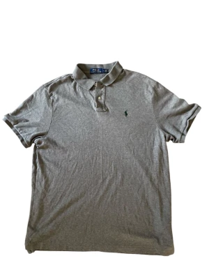 Ralph Lauren piké - Klassisk grå piké från Ralph Lauren i mycket fint skick! Tröjan är i storlek L och modellen är 191:) Hör av dig vid frågor eller funderingar! 