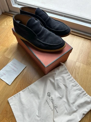 Loro Piana Open Walk skor  - Säljer nu mina LP open walks I navy! Bra skick på mockan och lite mindre bra på själva sulan då den stått och blivit hård med tiden de inte använts! Fortfarande helt brukliga och har används utan problem senaste månaderna! Går att byta sula för någon tusenlapp och då kan de hålla hur länge som helst. Storlek 45. Box och dustbag samt kvittot på bild kommer med! Köptes för 670£ i Harrods köpcentrum i London, ungefär 8000-9000sek! Skriv gärna vid frågor!