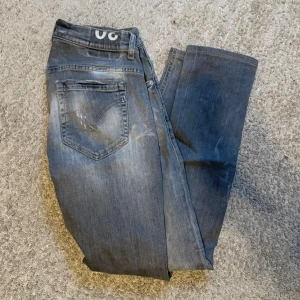 Dondup jeans modell George - Säljer ett par grå skinny jeans från Dondup med klassisk femficksdesign och lätt slitna detaljer. 