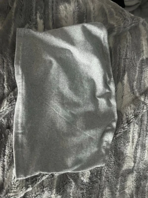 Grå tubtopp i mjukt material - En enkel och stilren grå tubtopp i mjukt och stretchigt tyg. lätt att matcha med olika outfits. har en slät yta och är utan synliga mönster eller loggor.