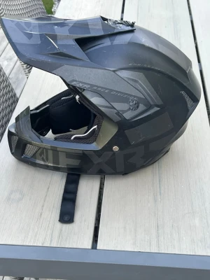 Svart crosshjälm från FXR - Säljer en svart crosshjälm från FXR med matt finish och diskreta gråa detaljer. Hjälmen har ventilation vid hakan och sidorna samt justerbar skärm framtill. Perfekt för motocross, moppe och fyrhjuling. Den har lite repor men inget som gör den sämre. PRIS KAN DISKUTERAS 