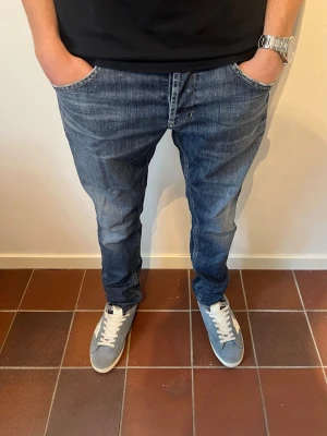 Dondup jeans  - Säljer ett par riktigt feta blå jeans från Dondup i slim och snygga slitningar. Passar perfekt nu inför sommaren. Hör av er vid intresse eller frågor. Dondups storlekar är lite skumma men W33. Modellen är 180 cm och väger 65 kg