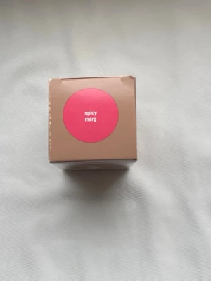 Rhode Pocket Blush Spicy Marg - Rhode Pocket Blush i nyansen Spicy Marg är ett rouge i stickformat. Förpackningen är kompakt och smidig att ta med. Färgen är en djup, varm rosa med inslag av rött som ger kinderna en fräsch och livlig look. Innehåller 5,3g produkt.