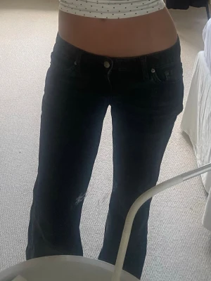 Svarta bootcut jeans med låg midja WEEKDAY - Säljer ett par svarta bootcut jeans med låg midja från weekday i ”nova low slim” stil. Jeansen har en lätt utsvängd passform nertill och stängs med knapp och dragkedja. Perfekta för dig som gillar en avslappnad och trendig stil. Jeansen har lite slit i t.ex nedre delen eller fickan (se bild 5-6) men det är inget man märker av💕