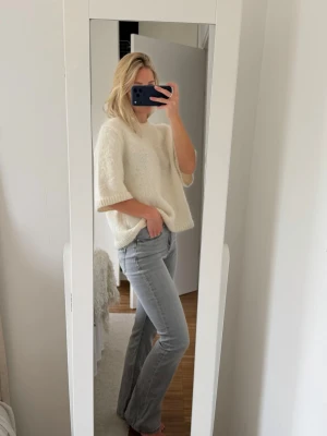 Ljusgrå bootcut jeans - Säljer ett par ljusgrå bootcut jeans med normalhög midja. Jeansen har en snygg tvätt och är tillverkade i ett mjukt denimtyg med lite stretch för extra komfort. Perfekta för dig som gillar en avslappnad men trendig look.