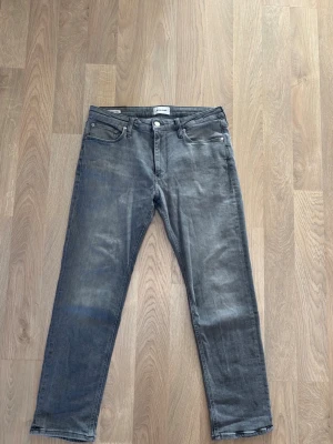 Grå Jack & Jones jeans - Ett par gråa raka Jack & Jones jeans i storlek, W 32, L 30. Mycket bra skick, använda ett fåtal gånger. 