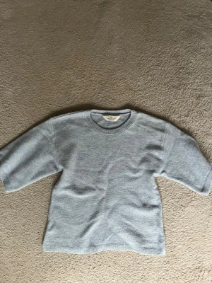 Ljusblå stickad tröja h&m - En stilren ljusblå stickad tröja från h&m med rund halsringning och raka ärmar. Tröjan har en minimalistisk design och är gjord i mjukt material som känns skönt mot huden. Perfekt för dig som gillar enkel och clean stil.