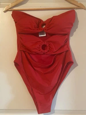 Röd bandeau baddräkt från H&M - Trendig röd bandeau baddräkt från H&M med två snygga cut-outs framtill. Köpt förra sommaren men aldrig använd då jag har massa andra badkläder 💕
