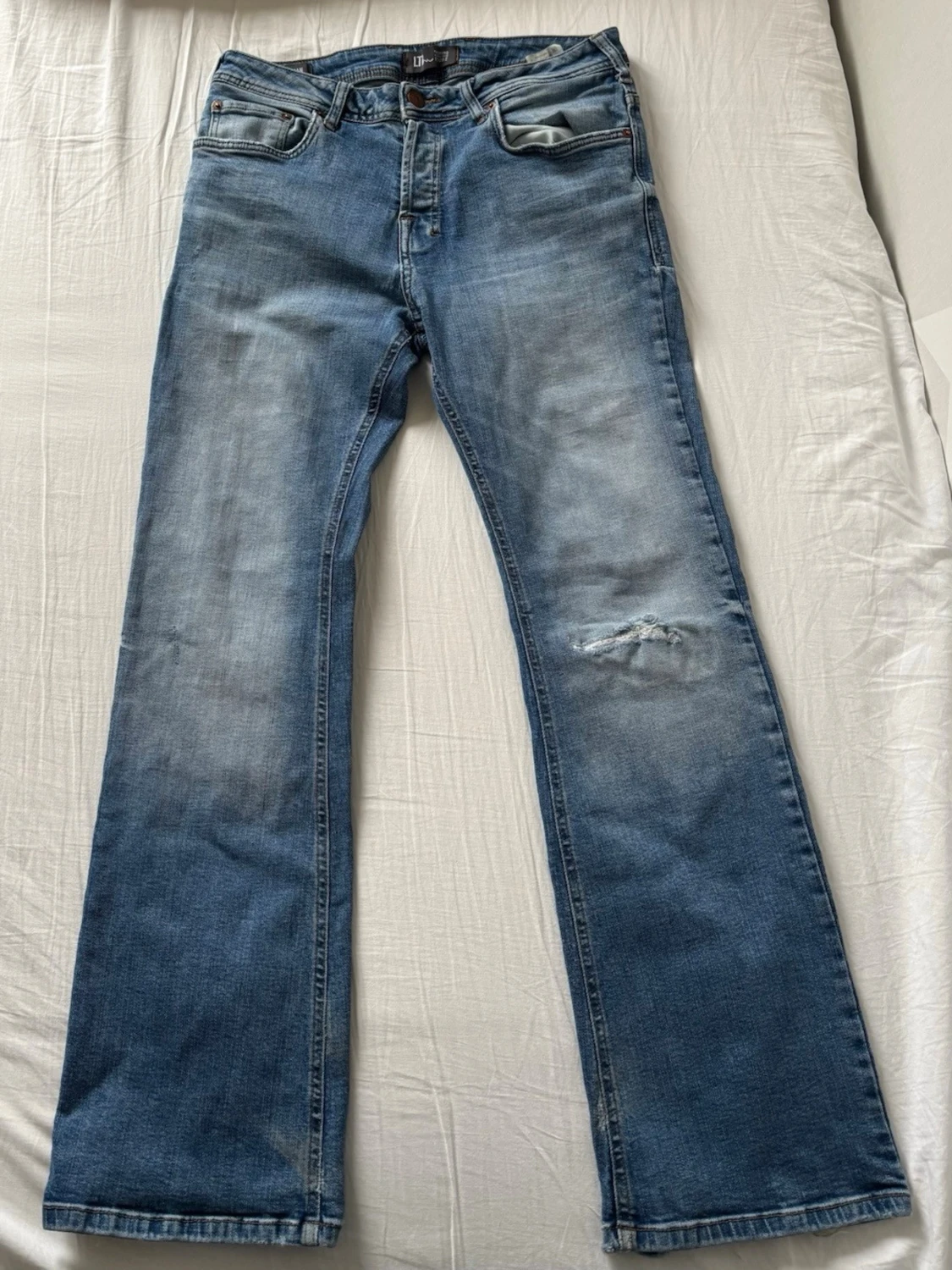 Blå bootcut jeans med slitningar