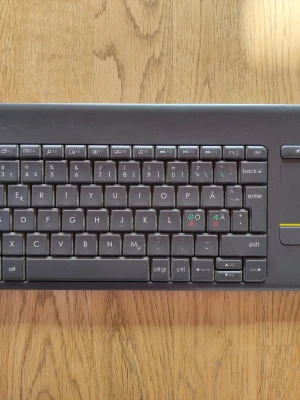 Logitech K400+ trådlöst tangentbord - Säljer ett svart Logitech K400+ trådlöst tangentbord med inbyggd touchpad. Tangentbordet har nordisk layout och är gjort av plast. Perfekt för att styra datorn från soffan eller till mediacenter.