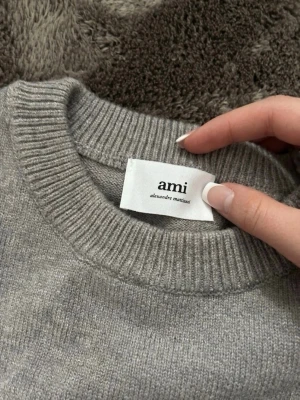 Ami Paris tröja  - Ami Paris tröja i grå färg säljes. Väldigt sparsamt använd och i mycket fint skick utan anmärkningar.  Tröjan tillhörde mitt ex, men eftersom vi har gjort slut används den inte längre och får därför gå vidare till någon som faktiskt kommer ha nytta av den.  ✔️ Nästan som ny ✔️ 100 % äkta ✔️ Stilren och tidlös design ✔️ Betydligt billigare än nypris ✔️ Snabb affär prioriteras.