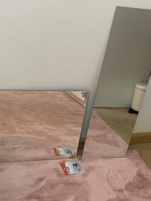 Två rektangulära speglar med fästen - Säljer två rektangulära speglar, en stående och en liggande, perfekta för hall eller sovrum. Medföljer ett paket spegelhållare från Hard Head (4 delar) för enkel upphängning. Speglarna har enkel, stilren design utan ram.