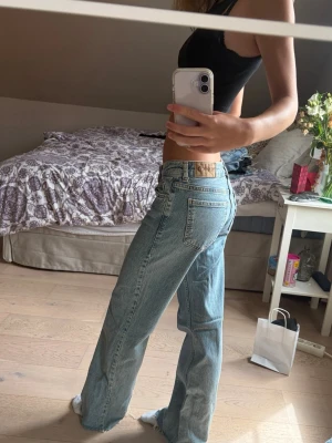 Ljusblå raka jeans från nakd - Säljer ett par ljusblå jeans från nakd med rak passform och klassisk femficksdesign. Jeansen har hög midja och råa kanter vid bensluten för en avslappnad vibe.