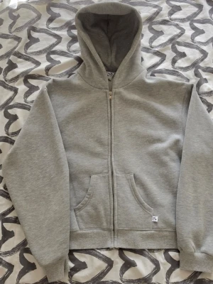 Ljusgrå zip hoodie akimbo club - Ljusgrå "akimbo club" hoodie. Mjukt, borstat innerfoder. Den e lite kort o baggy, fråga om mått om ni är osäkra! Har knappt använt den o ni fattar varför priset är så lågt 🤐. Kvalitén e as bra o det e mjukaste o hoodien jag haft 😁