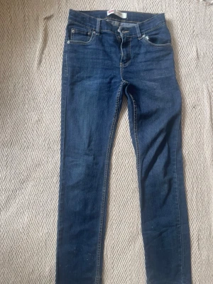 Mörkblå skinny jeans från Levi's - Snygga mörkblå skinny jeans från Levi's med klassisk femficksmodell och guldfärgade sömmar. Jeansen har normal midja och är tillverkade i ett mjukt denimtyg som sitter tight hela vägen ner. Perfekta för en trendig och avslappnad look.
