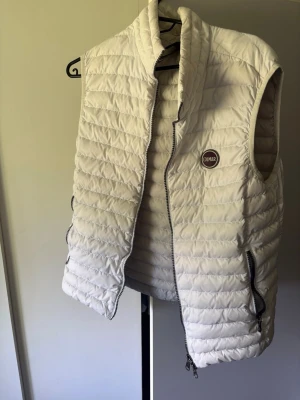 COLMAR originals - Säljer en stilren vit väst som passar bra för sommaren, extremt fint till alla kläder och bekväm och lätt! Frågor eller vid funderingar hör av er