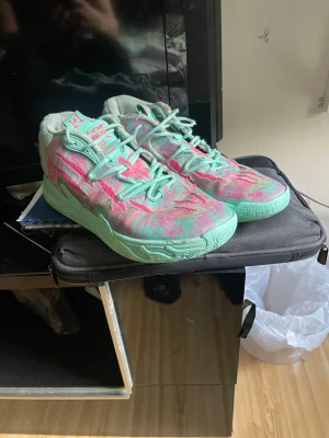 Mb03 Miami  - Unika sneakers från Li-Ning med mintgröna sulor och detaljer, samt rosa och gröna mönster på ovandelen. Skorna har en låg siluett och är tillverkade i textilmaterial med syntetiska inslag. Perfekta för dig som vill sticka ut med färg och stil.