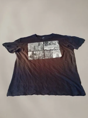 Svart t-shirt med stadsmotiv - Cool svart t-shirt med tryck av stadsmotiv i vitt och grått på bröstet. Klassisk passform och korta ärmar, perfekt till jeans eller shorts. Tillverkad i mjuk bomull för skön känsla hela dagen.