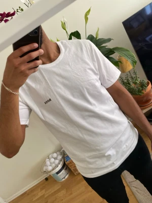 Vit BOSS t-shirt i bomull - Snygg vit t-shirt från BOSS med liten logga på bröstet. Klassisk rund halsringning och korta ärmar. Tillverkad i mjuk bomull som känns skön mot huden. Perfekt för en clean och stilren look.
