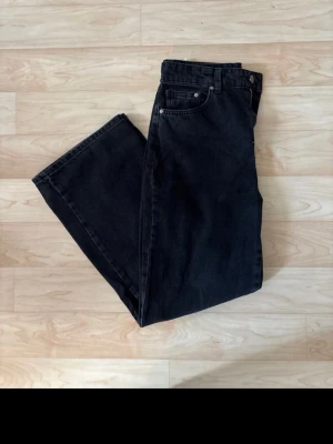 Svarta raka jeans med hög midja - Säljer ett par svarta jeans med rak passform och hög midja. Klassisk femficksmodell med knapp och dragkedja framtill. Jeansen har en enkel och stilren look, perfekta till alla typer av outfits. 