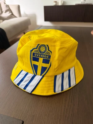 Sverige Fiskehatt Buckethat Solhatt Landslaget - Handgjord fiskehatt tillverkad av en Sverige-landslagströja. Hatten är sydd i one size-modell och passar de flesta vuxna.  