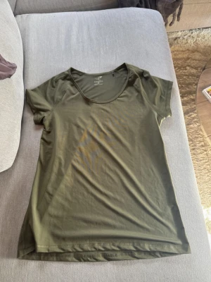 Olivgrön tränings-tshirt Energetics - Snygg olivgrön tränings-tshirt från Energetics med rund halsringning och korta ärmar. Tillverkad i ett lätt och snabbtorkande material med DRYPLUS eco-teknologi som håller dig fräsch under träningspasset. Perfekt för gymmet eller löprundan.