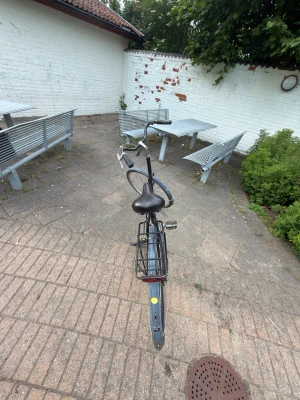 Svart klassisk damcykel - Säljer en svart klassisk damcykel med pakethållare och stänkskärmar. Cykeln har upprätt styre, ringklocka och bekväm sadel. Perfekt för stadskörning och vardagspendling. Inga växlar syns på styret.