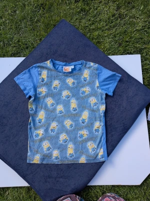Tshirt minioner från Lindex strl 122/128 - Pyttelitet hål på ena axeln  Blekare än ny / tvättad   Tröja Minionerna