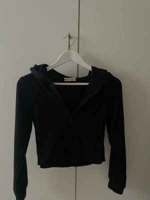Svart zip hoodie - Säljer en zip-up hoodie som jag köpt på en marknad i Thailand. Materialet är ribbat och hoodien är lite croppad, den sitter lagom tight. Har aldrig använt den så det är in princip helt ny typ. Jag skulle säga att den är i storlek s-xs då det inte står någon storlek i den