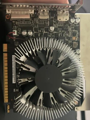 ASUS GTX 1050 2GB grafikkort - Säljer ett ASUS GTX 1050 2GB grafikkort med stor kylfläkt och metallkylare. Kortet har HDMI, DVI och DisplayPort-utgångar. Svart kretskort med silverfärgad kylfläns och tydlig ASUS-logga. Perfekt för gaming eller uppgradering av dator.