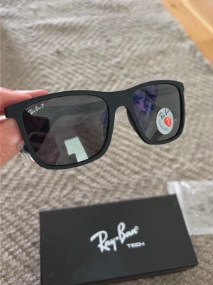 Svarta Ray-Ban Tech solglasögon - Snygga svarta Ray-Ban Tech solglasögon med klassisk rektangulär form och polariserade linser. Kommer med originalfodral och putsduk. Perfekta för dig som vill ha en stilren och tidlös look.