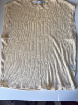 Beige ribbad ärmlös topp från Zara - Säljer en ljusgul ärmlös topp från Zara i ribbat material. 