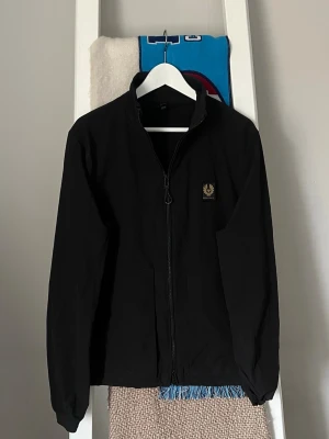 Windbreaker Jacka från Belstaff - Snygg svart vindjacka från Belstaff. Den är i bra skick. Köpte den nyligen för runt 2000kr.
