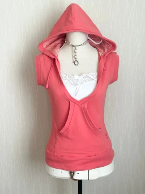Rosa hoodie med korta ärmar och huva - Snygg rosa hoodie med korta ärmar och djup V-ringning. Spetslinne endast för visning 