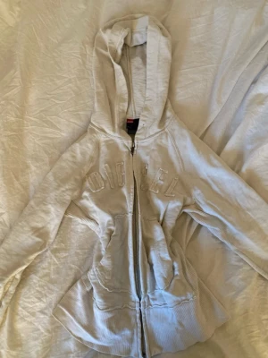 Vit vintage hoodie med dragkedja från Diesel - Säljer en vintage vit hoodie från Diesel med dragkedja framtill och broderad logga över bröstet💓 Hoodien har huva, ribbade muddar och fickor på sidorna💓 PRISET GÅR ATT DISKUTERAS