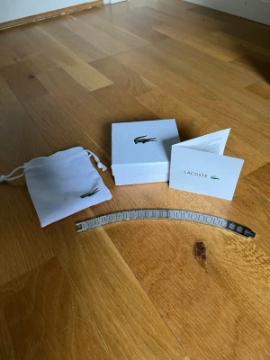 Lacoste armband - Mycket snyggt Lacoste armband i stål. Går att ta av länkar. Aldrig använt. Skickar inom 48 timmar.