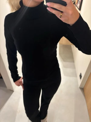 Svart polotröja i mjukt material - Säljer en svart polotröja med lång ärm och figurnära passform. Tröjan är enkel och stilren, perfekt att matcha med olika outfits🌸