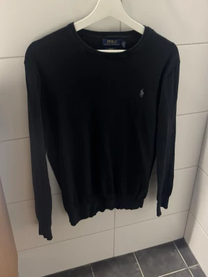 Svart stickad tröja Polo Ralph Lauren - Svart tröja från Polo Ralph Lauren. Enkel och stilren design som funkar till allt. Storlek M