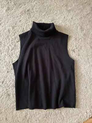 Svart stickad polotopp - En svart stickad topp med hög polokrage.